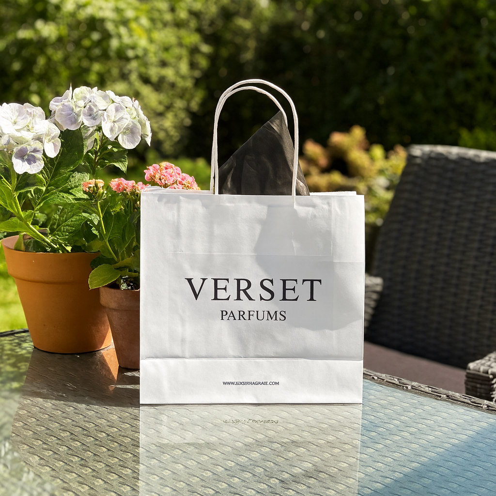 Verset Parfums shopping bag on a table with flowers in the background